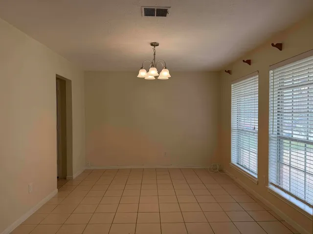 an empty room with chandelier fan