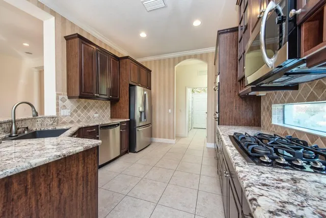a kitchen with stainless steel appliances granite countertop a stove a sink and a refrigerator