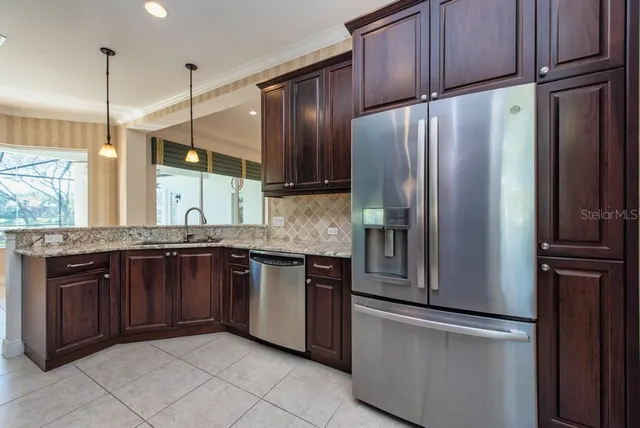 a kitchen with stainless steel appliances granite countertop a refrigerator and a sink
