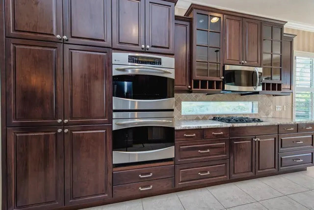 a kitchen with granite countertop wooden cabinets and stainless steel appliances