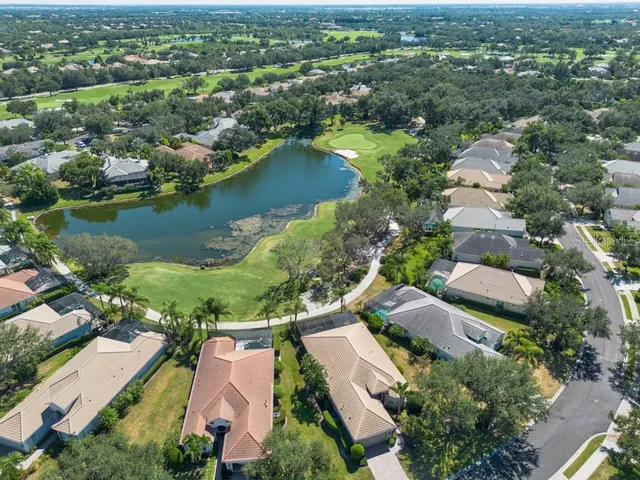 an aerial view of residential houses with outdoor space and lake view