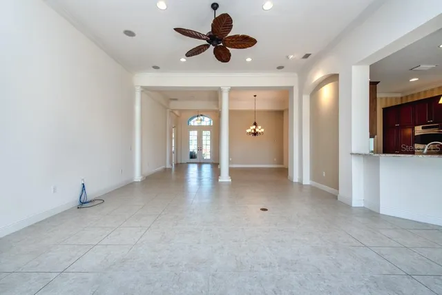 a view of an empty room and a ceiling fan