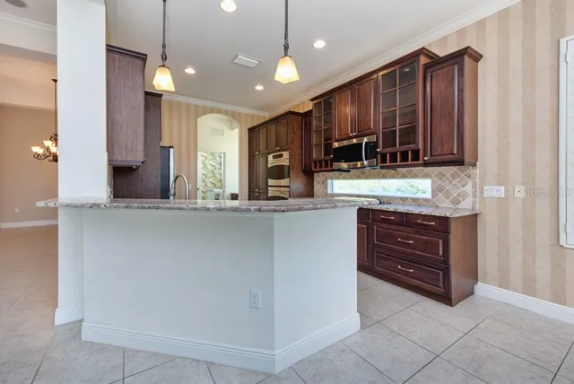 a kitchen with stainless steel appliances granite countertop a refrigerator and a stove top oven