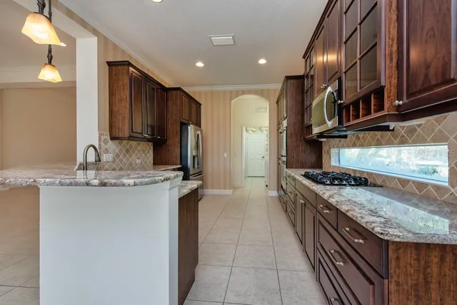 a kitchen with stainless steel appliances granite countertop a stove a sink and a refrigerator