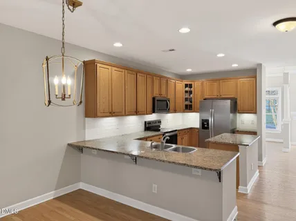 a kitchen with stainless steel appliances granite countertop a sink and a refrigerator
