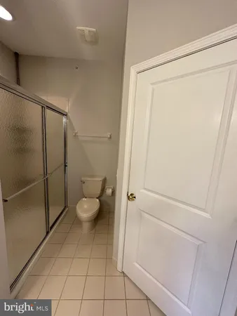 a bathroom with a granite countertop toilet and a shower