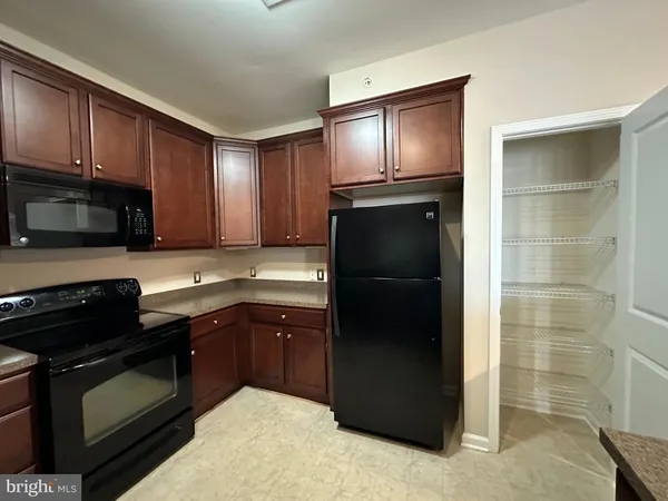 a kitchen with a refrigerator sink and cabinets