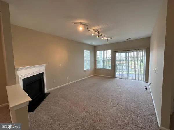 a view of an empty room with a fireplace and a window