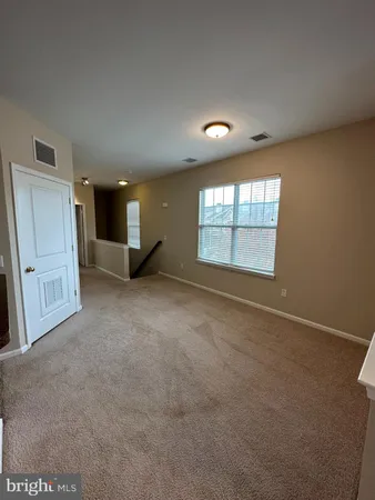 an empty room with a window and fireplace