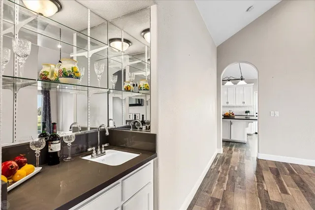 a kitchen with granite countertop white cabinets and a sink