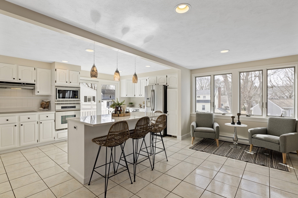 61 School Street Lexington, MA 02421 - Photo 11 of 42 a kitchen with stainless steel appliances kitchen island granite countertop a stove a sink a dining table and chairs