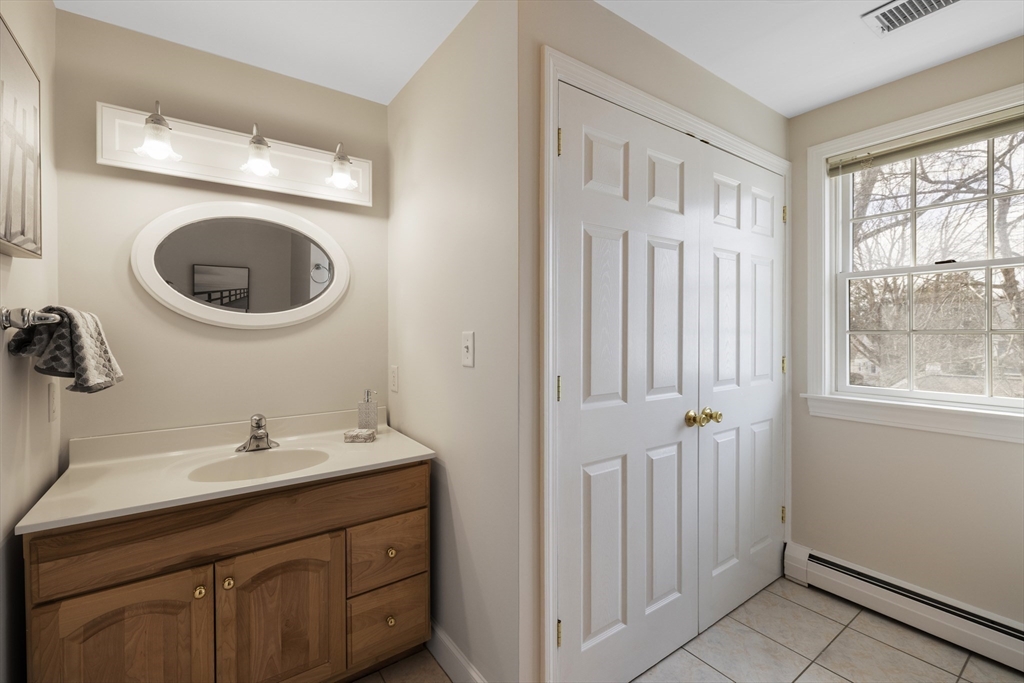 61 School Street Lexington, MA 02421 - Photo 27 of 42 a bathroom with a sink a toilet and a mirror