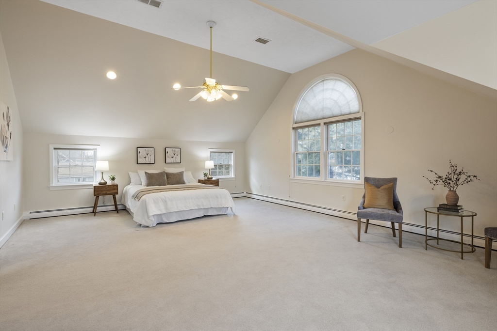 61 School Street Lexington, MA 02421 - Photo 33 of 42 a spacious bedroom with a bed a chandelier and a window