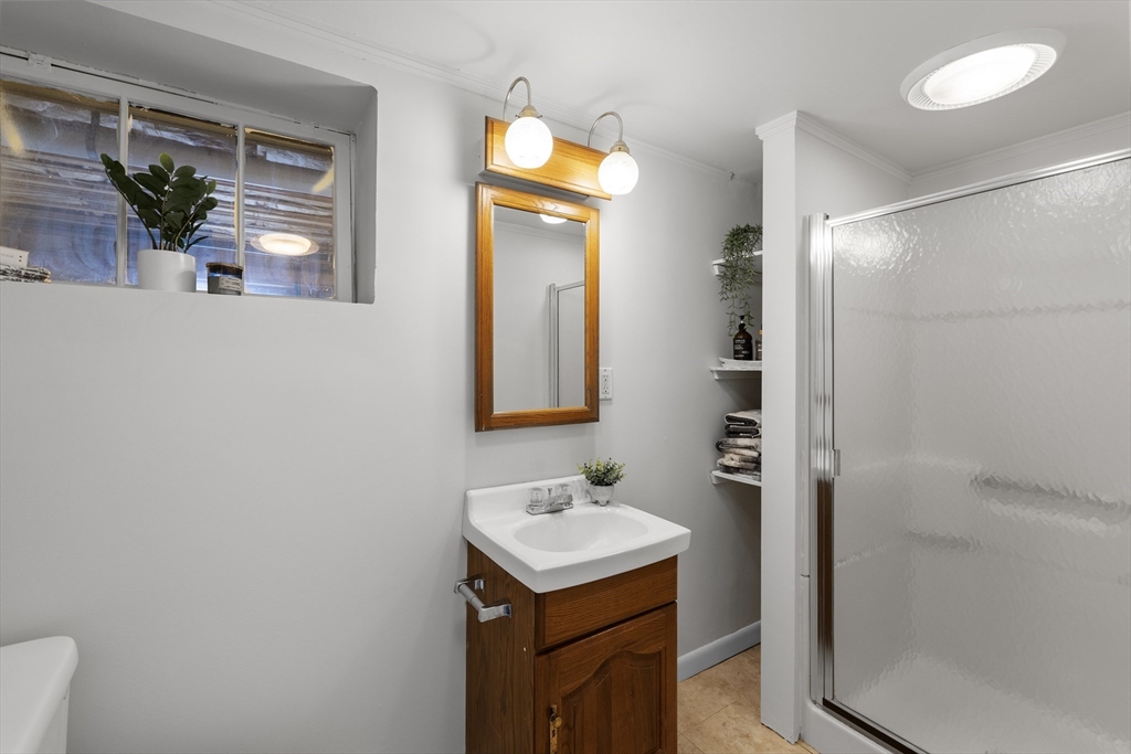 61 School Street Lexington, MA 02421 - Photo 38 of 42 a bathroom with a sink a light fixture and a mirror
