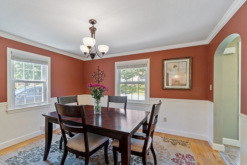 43 Sylvan Road Lancaster, MA 01523 - Photo 9 of 26 a dining room with wooden floor a chandelier a wooden table and chairs
