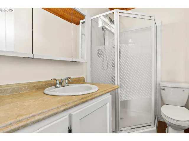 a bathroom with a granite countertop sink a toilet and a mirror
