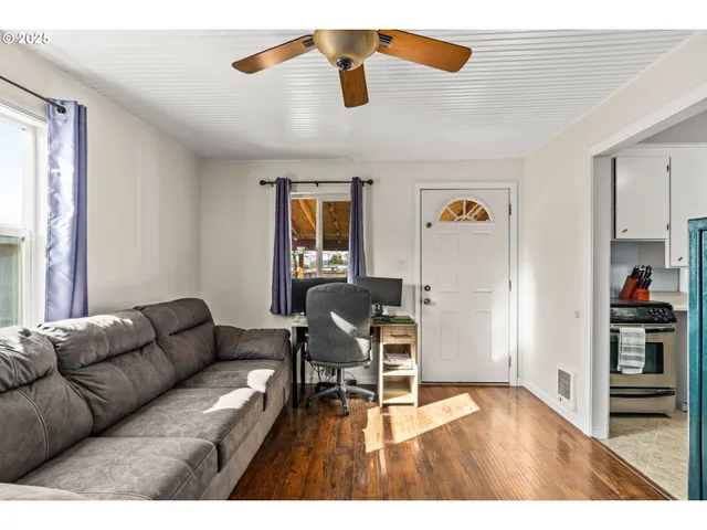 a living room with furniture and a wooden floor