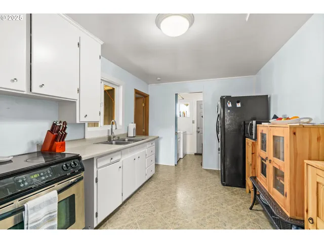 a kitchen with stainless steel appliances granite countertop a refrigerator a stove and a sink