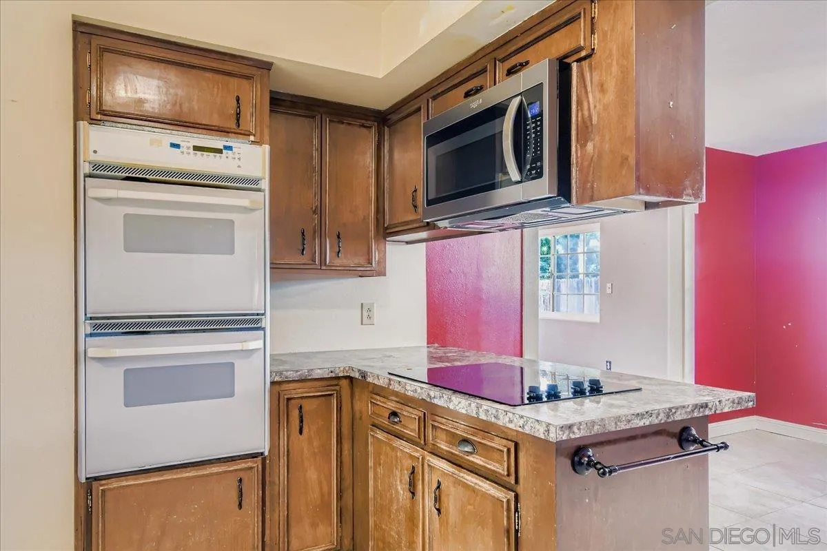 3245 Valley Street Carlsbad, CA 92008 - Photo 16 of 30 a kitchen with granite countertop cabinets stainless steel appliances and a counter space