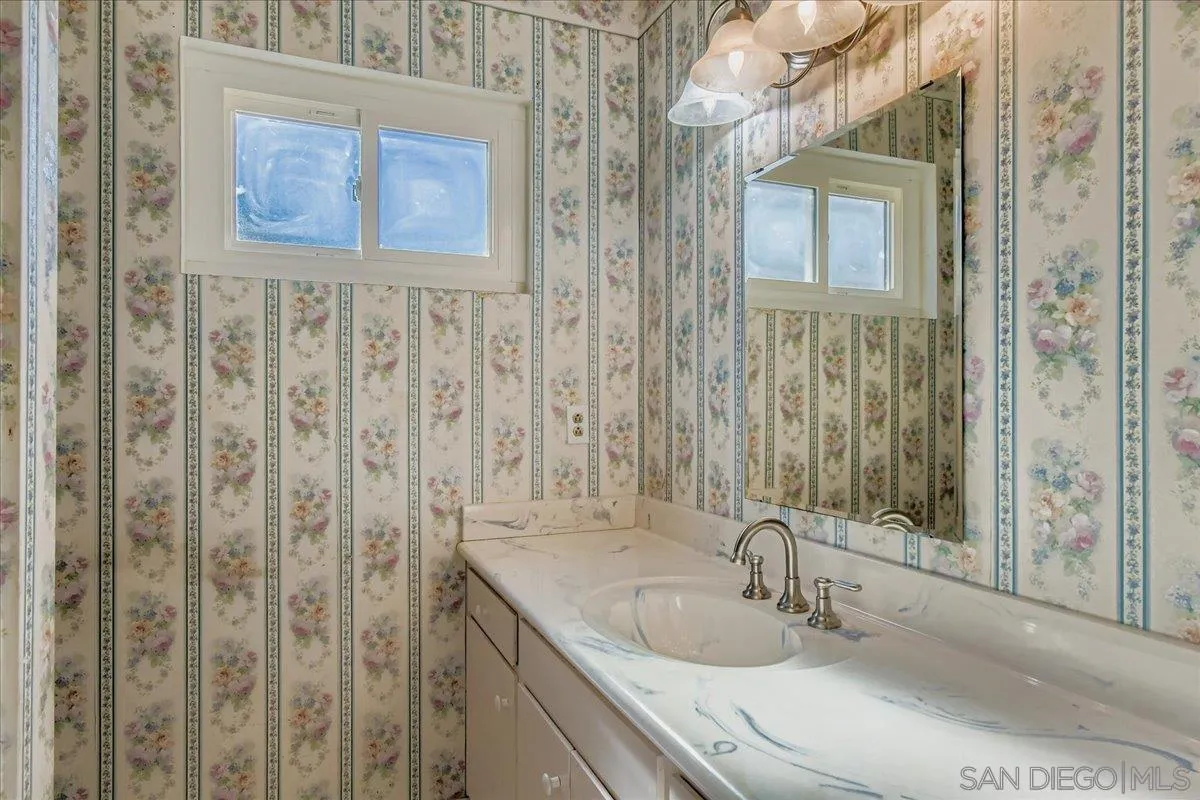 3245 Valley Street Carlsbad, CA 92008 - Photo 21 of 30 a bathroom with a granite countertop sink a mirror and shower