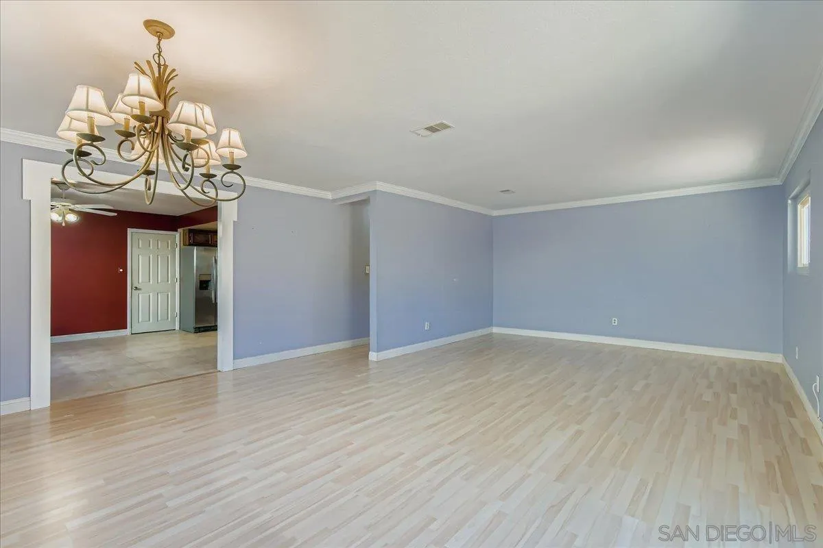 3245 Valley Street Carlsbad, CA 92008 - Photo 8 of 30 a view of an empty room with wooden floor and chandelier