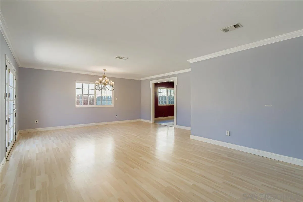 3245 Valley Street Carlsbad, CA 92008 - Photo 9 of 30 an empty room with wooden floor and windows
