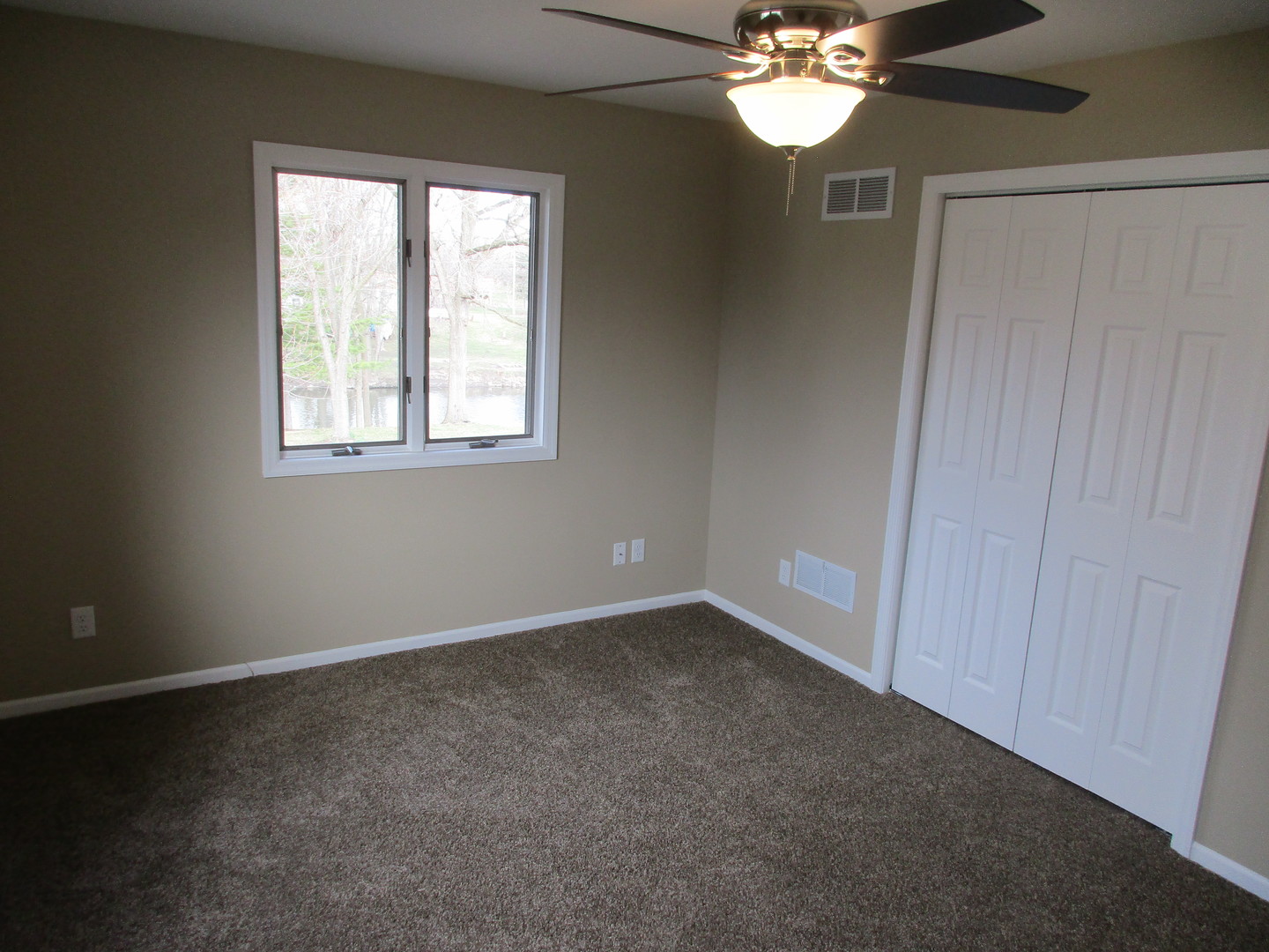 507 San Carlos Road Minooka, IL 60447 - Photo 27 of 48 an empty room with a chandelier fan and windows