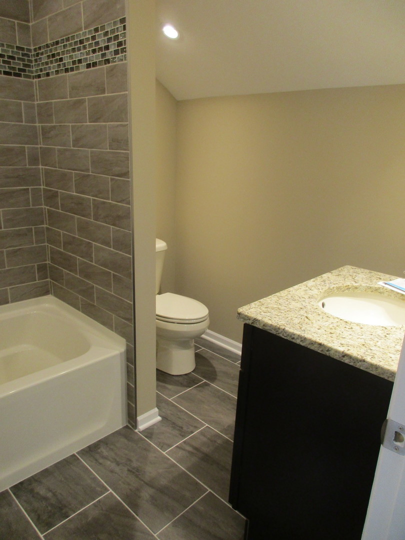 507 San Carlos Road Minooka, IL 60447 - Photo 30 of 48 a bathroom with a granite countertop sink toilet and bathtub