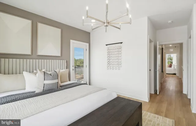 a bedroom with a large bed a chandelier and a window