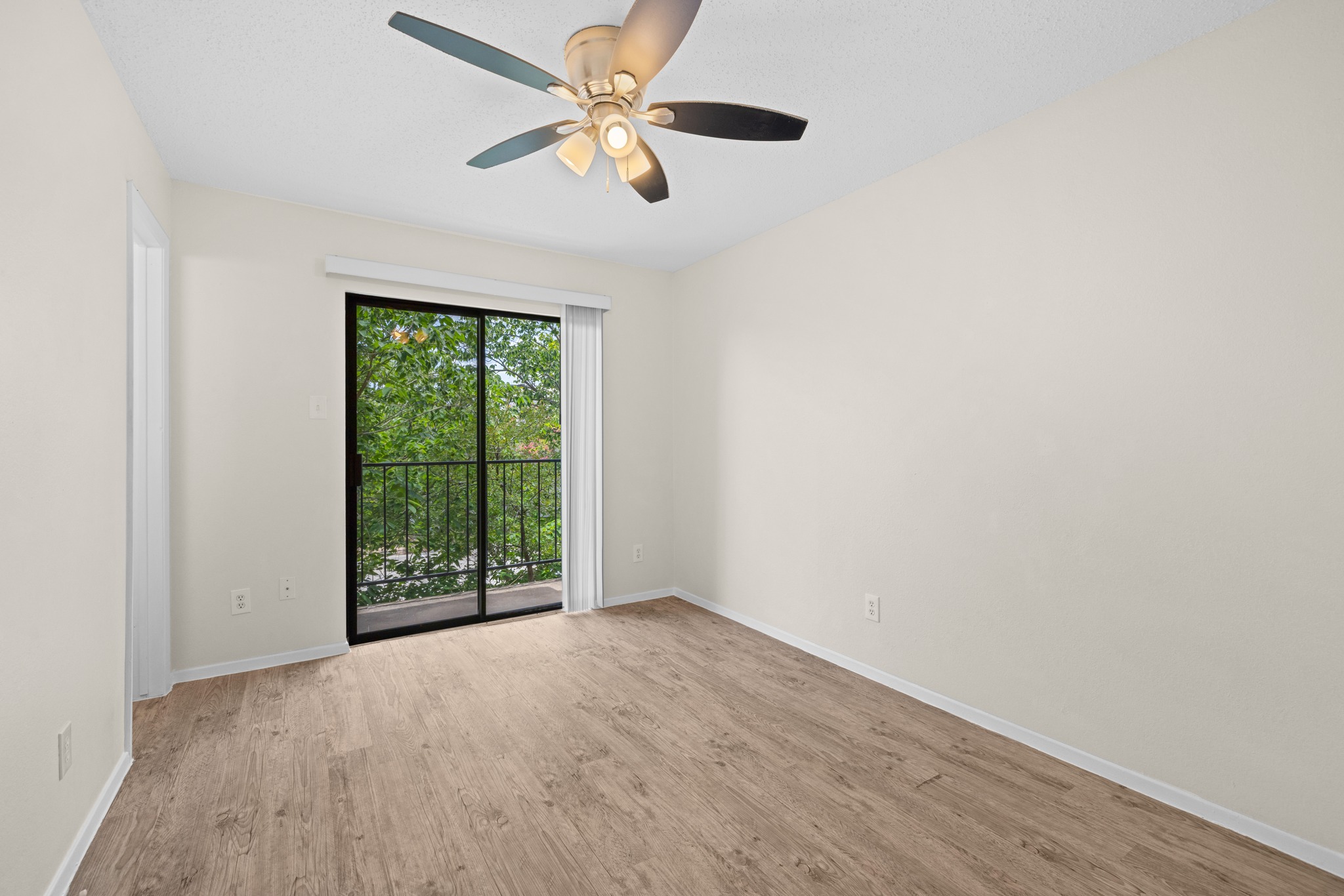 9079 Jollyville Road, Unit 301 Austin, TX 78759 - Photo 30 of 38 #203 A versatile room featuring a contemporary ceiling fan and a sliding glass door opening to a private balcony.