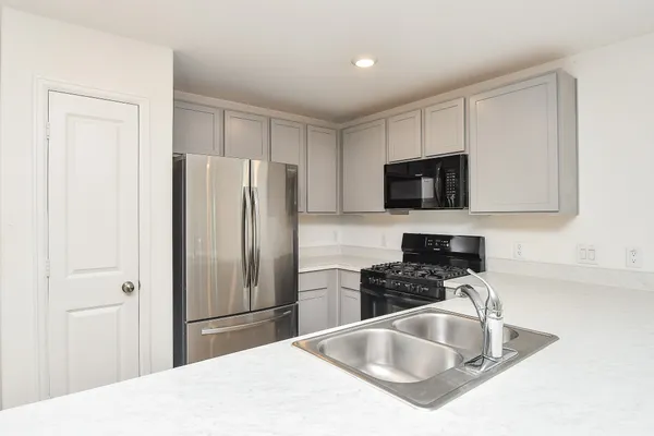 a kitchen with granite countertop a refrigerator and a sink