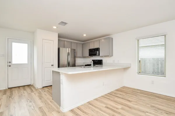 a view of kitchen with stainless steel appliances granite countertop a refrigerator and a stove top oven