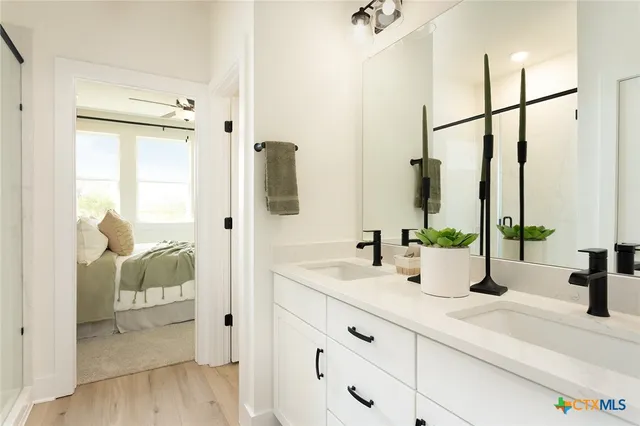 a bathroom with double vanity sink a mirror and shower