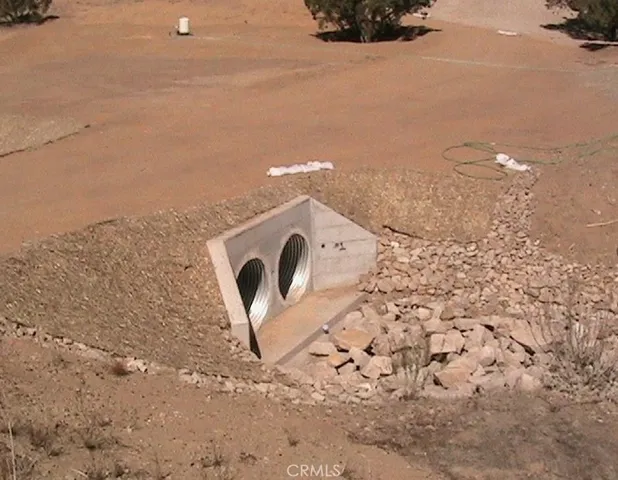 a view of a dry yard with mountains in the background