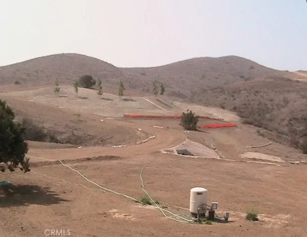 a view of a dry yard with mountains in the background