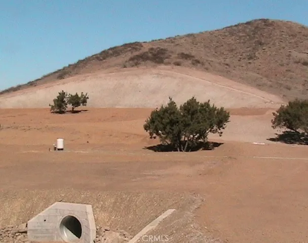 a view of a dry yard with mountains