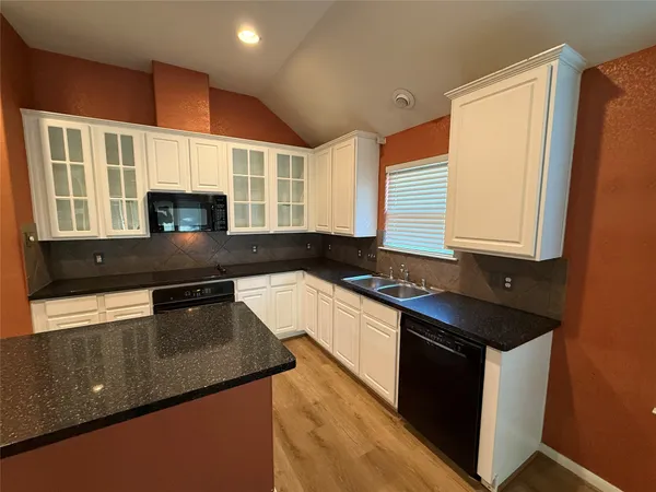a kitchen with granite countertop stainless steel appliances sink stove microwave and cabinets