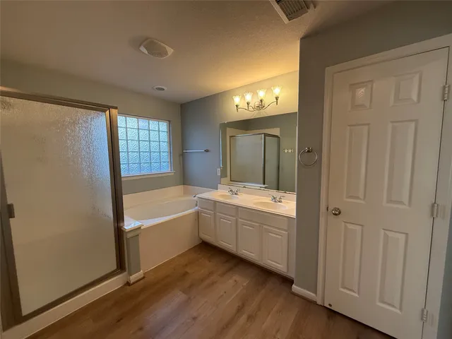 a large bathroom with a tub sink shower and mirror