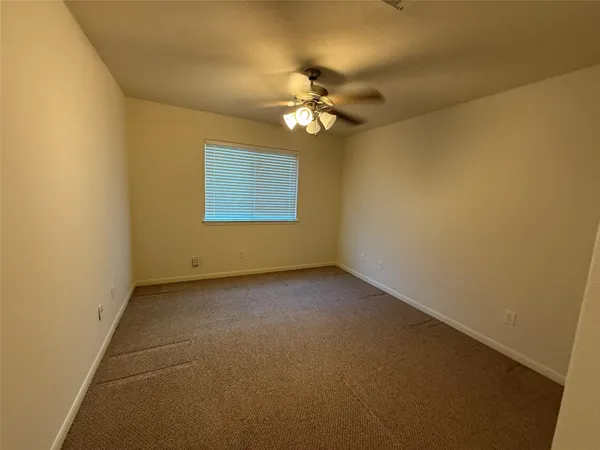 a view of a livingroom with a ceiling fan and window