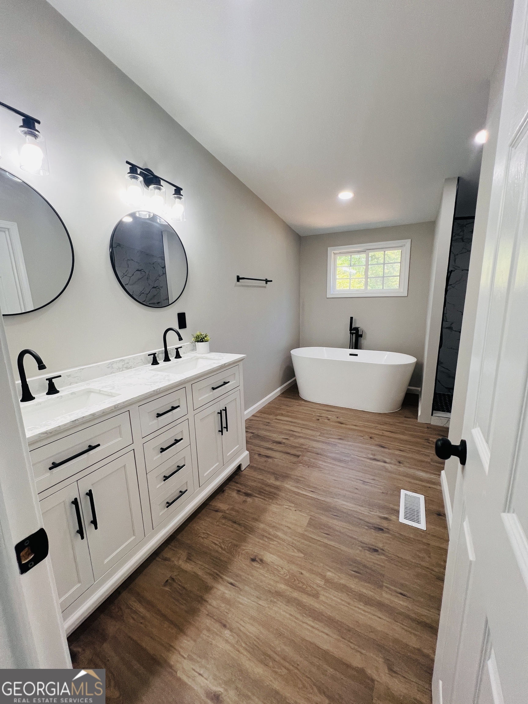 110 Kathy Lane Temple, GA 30179 - Photo 7 of 24 a spacious bathroom with a double vanity sink a mirror and a bathtub
