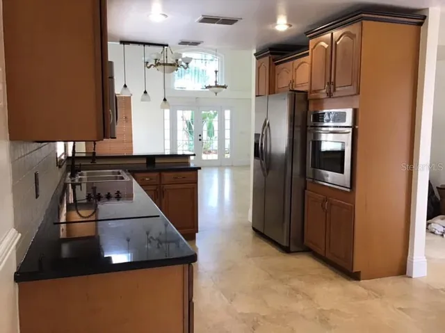 a kitchen with granite countertop cabinets stainless steel appliances and a sink
