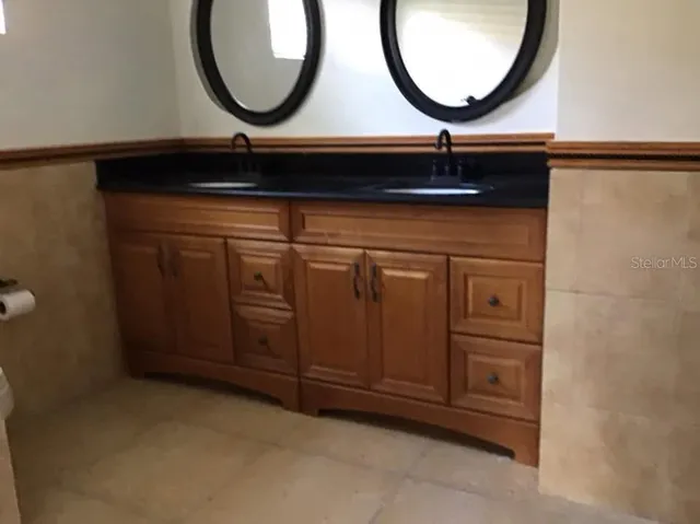 a bathroom with a sink a toilet a shower and a mirror