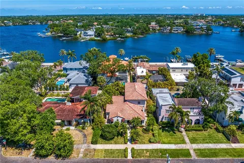 an aerial view of ocean and residential houses with outdoor space