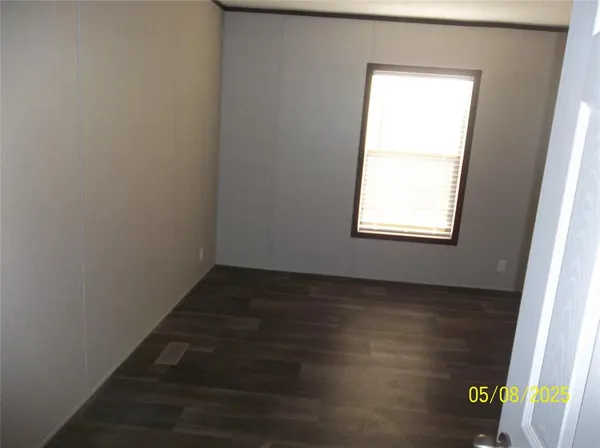 an empty room with wooden floor and a window