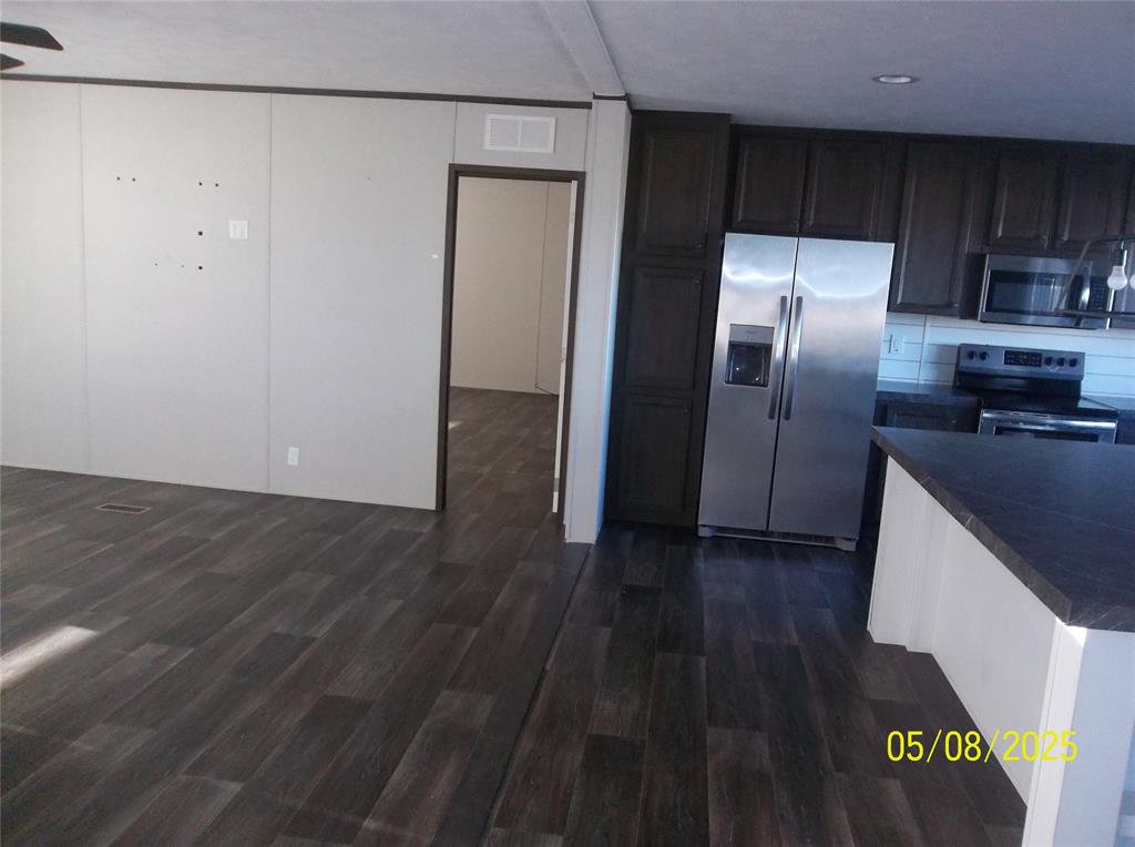 531 Blair Road Waxahachie, TX 75165 - Photo 17 of 40 a kitchen with granite countertop a refrigerator a sink and wooden floor