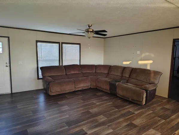 a living room with furniture and a ceiling fan