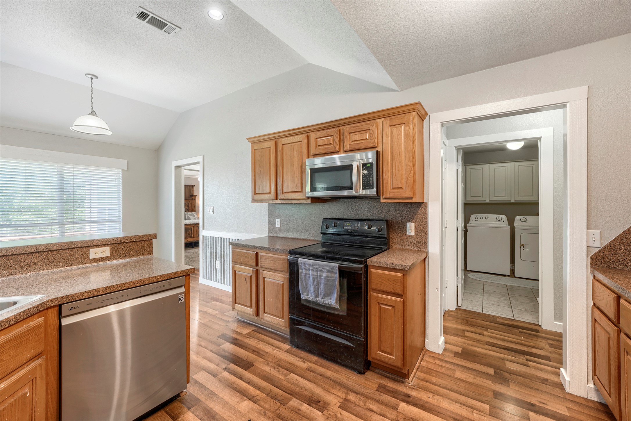 1105 2nd Street Jarrell, TX 76537 - Photo 10 of 27 A well-equipped kitchen features wood flooring and a convenient laundry area nearby.