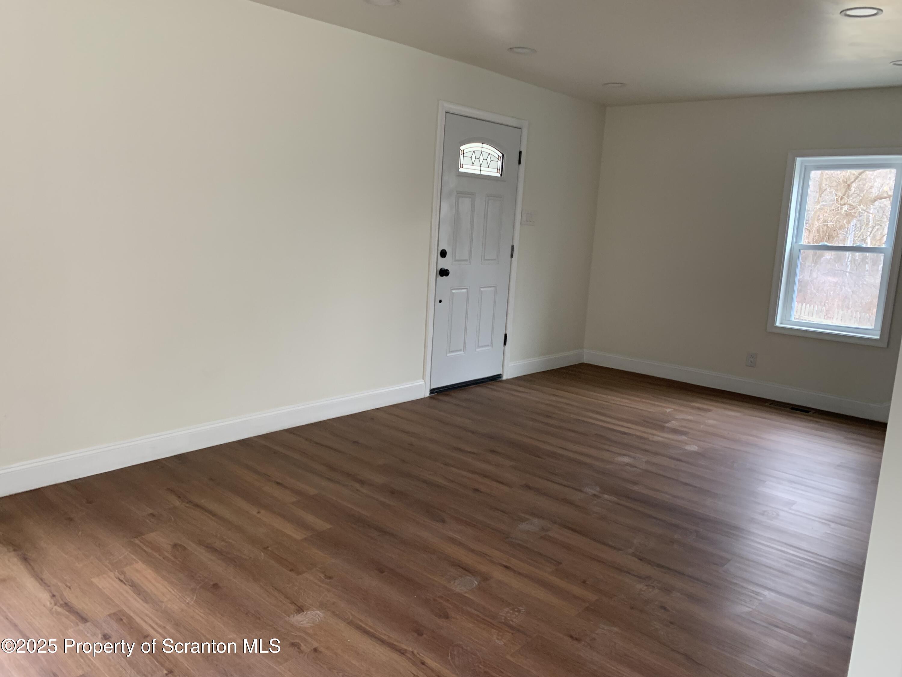 318 Simrell Road Clarks Summit, PA 18411 - Photo 14 of 30 an empty room with wooden floor and windows