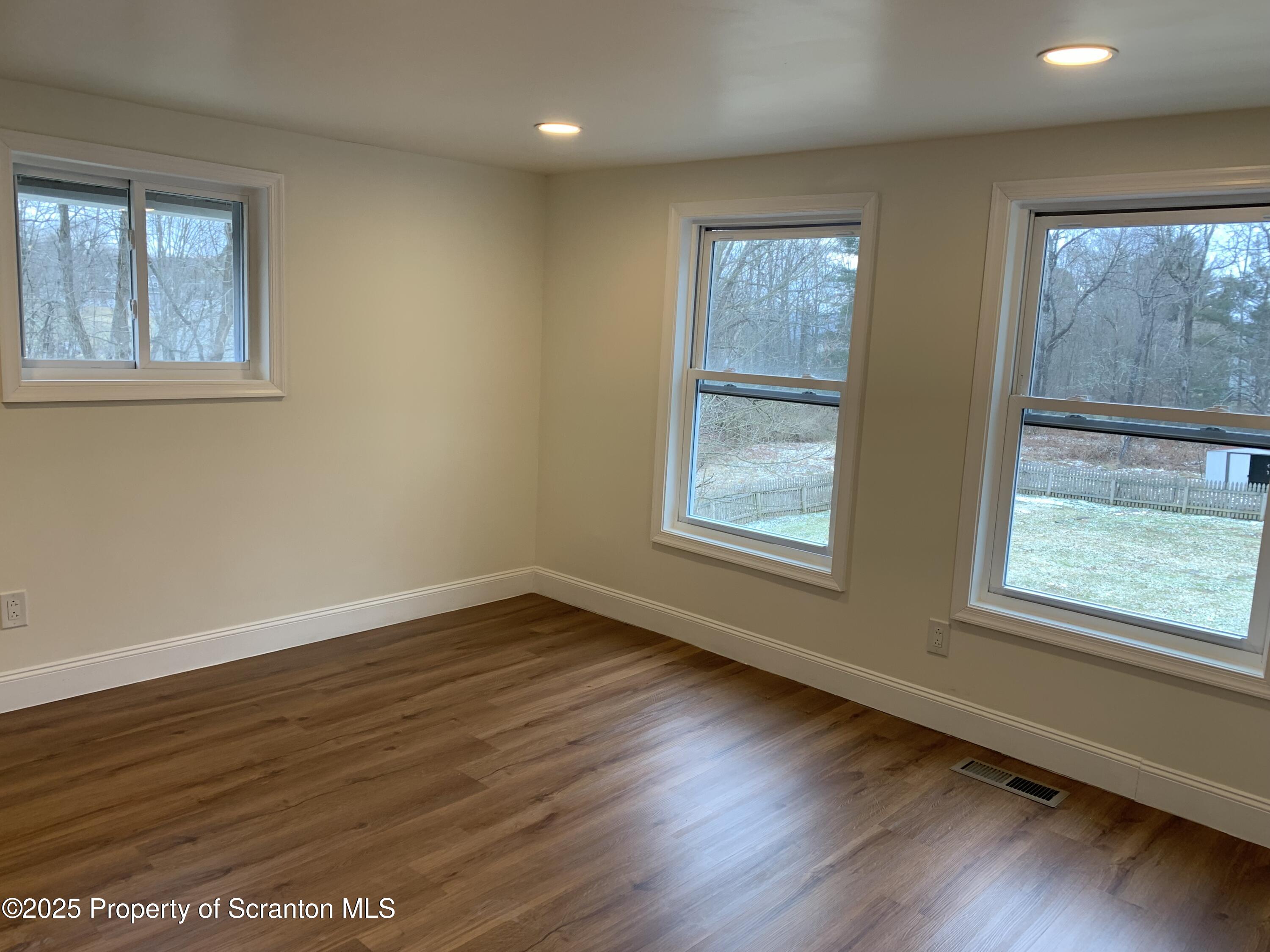 318 Simrell Road Clarks Summit, PA 18411 - Photo 16 of 30 a view of an empty room with wooden floor and windows