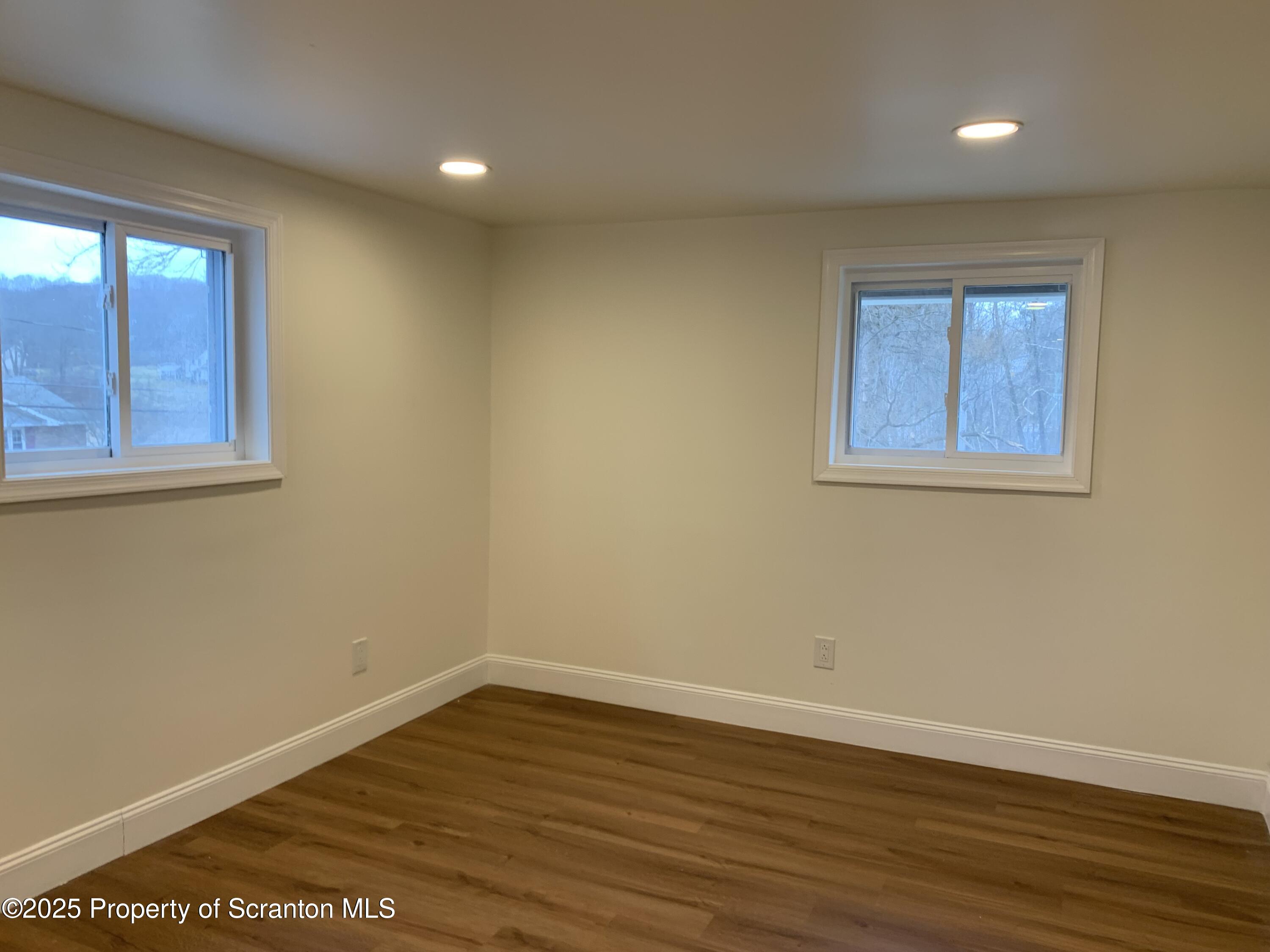 318 Simrell Road Clarks Summit, PA 18411 - Photo 17 of 30 a view of an empty room with wooden floor and a window